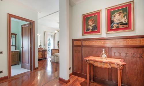 a living room with a table and paintings on the wall at Hotel Boutique Edelweiss La Garriga in La Garriga