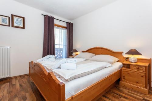 a bedroom with a bed with white sheets and a window at Appartements Schmidsendl in Lofer