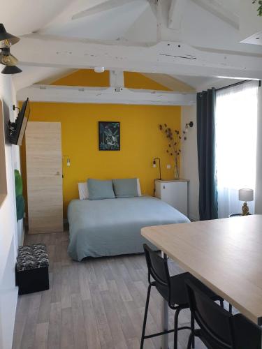 a bedroom with a bed and a table with chairs at Jungle et Nature in Gannat