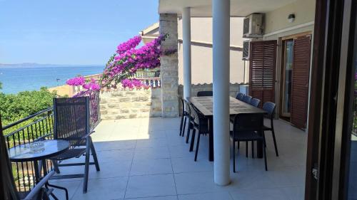 a balcony with a table and chairs and the ocean at Pansion Marta in Bibinje