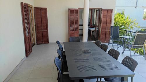 una mesa y sillas en una habitación con balcón en Pansion Marta, en Bibinje