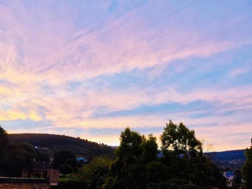 a cloudy sky with trees in the foreground at Su Casa Chase Valley VA in Pietermaritzburg