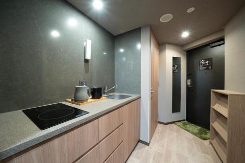 a kitchen with a sink and a counter top at KOKO HOTEL Residence Asakusa Kappabashi in Tokyo