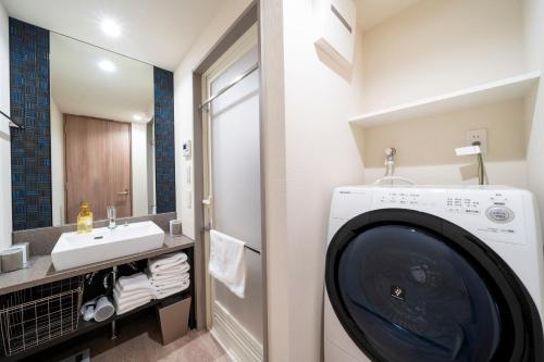 a bathroom with a washing machine and a sink at KOKO HOTEL Residence Asakusa Kappabashi in Tokyo