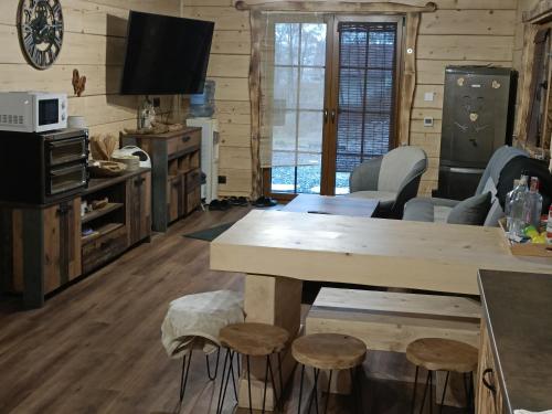 a kitchen and living room with a table and stools at Chata Peťo in Bžany