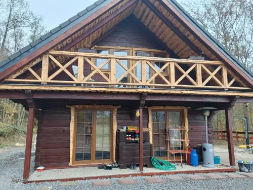 a log cabin with a wooden roof and two windows at Chata Peťo in Bžany