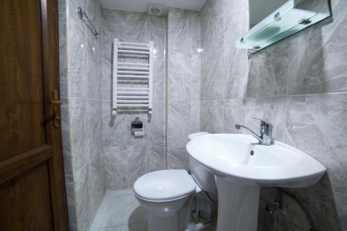 Gogichas tower في بورجومي: حمام مع حوض أبيض ومرحاض