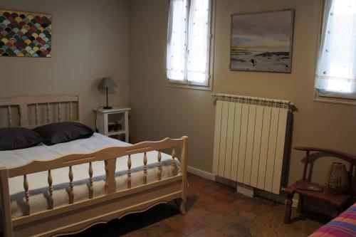 1 dormitorio con cama, radiador y ventanas en Chambre Coeur de Ville en Limoux