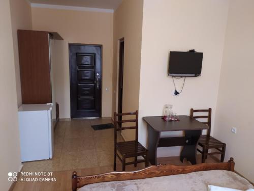 a room with a table and a tv and a door at Gogichas tower in Borjomi