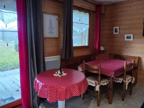 dwa stoły i krzesła w pokoju z oknem w obiekcie Les fermes du Lac Gerardmer w mieście Gérardmer