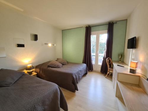 a hotel room with two beds and a window at Logis Hôtel Restaurant Le Mas De L'Olivier in Pont-Saint-Esprit