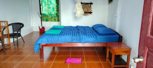 a bedroom with a bed with blue sheets and a table at Soksan Natura Beach in Koh Rong Island