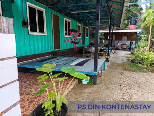 een groen en blauw huis met een tafel ervoor bij PS Din Kontenastay in Kota Bharu