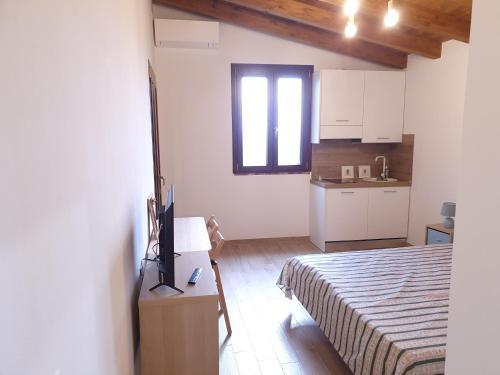 a bedroom with a bed and a small kitchen at La Casa di Bach in Perugia