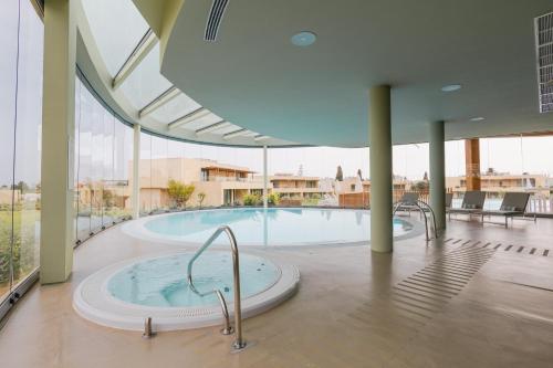 einen großen Pool mit Whirlpool in einem Gebäude in der Unterkunft White Shell Beach Villas in Porches