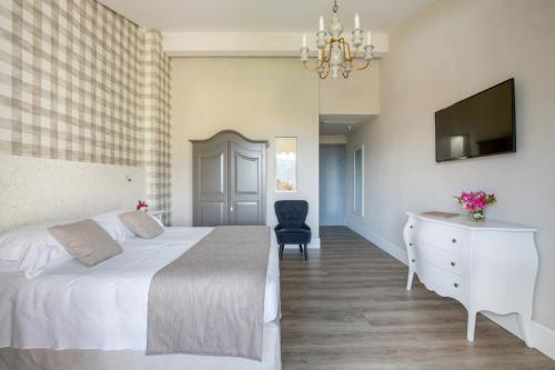 a bedroom with a bed and a desk and a television at Park Hotel Villa Belvedere in Cannobio