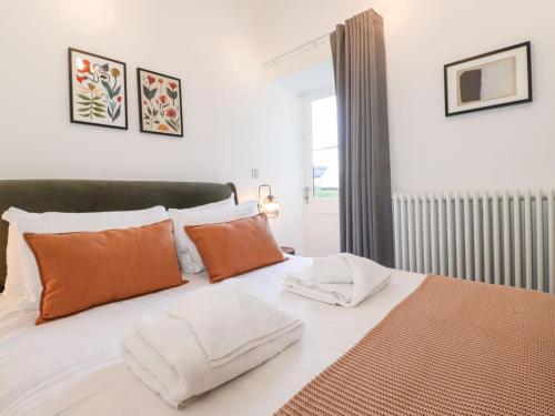 a bedroom with a bed with orange and white pillows at The Wilfred Suite Stone Cross Mansion in Ulverston