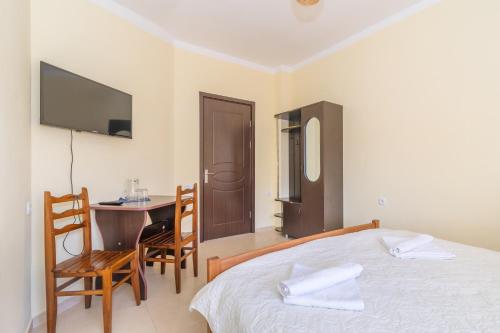 a bedroom with a bed and a table and a tv at Gogichas tower in Borjomi