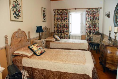 a bedroom with two beds and a window at Casal Santo Antonio in Sintra