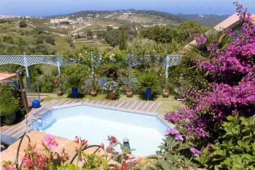 a swimming pool in a garden with flowers at Casal Santo Antonio in Sintra