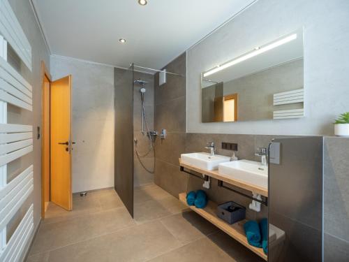 uma casa de banho com um lavatório, um chuveiro e um espelho. em Landhaus Barbara em Ramsau im Zillertal