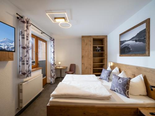 1 dormitorio con 1 cama en una habitación con montañas en Landhaus Barbara en Ramsau im Zillertal