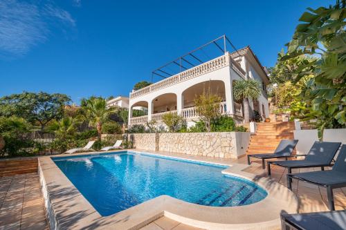 a swimming pool in front of a house at Villa Bendinat 10 - by Priority Villas in Portals Nous
