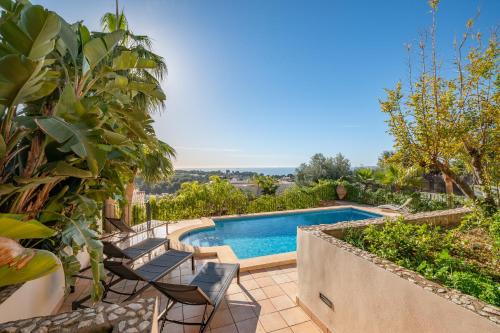 a swimming pool in a yard with chairs and trees at Villa Bendinat 10 - by Priority Villas in Portals Nous