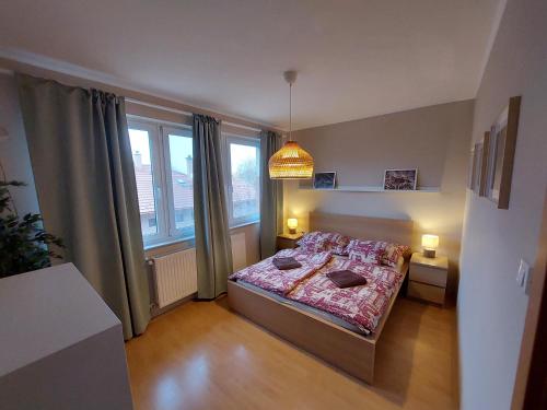 1 dormitorio con cama y ventana grande en Semiramis Apartman, en Cserkeszőlő