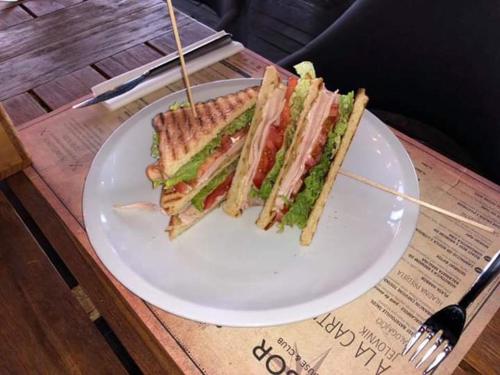 ein Sandwich auf einem weißen Teller auf einem Tisch in der Unterkunft Sky & Sun Luxury Rooms with private parking in the garage in Zadar