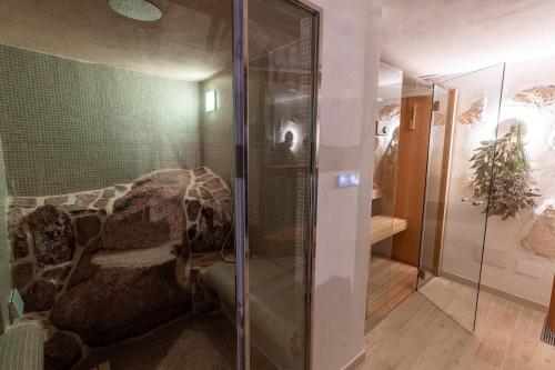 a glass shower in a bathroom with a couch at VILLA AMIRA Porto Cervo con vista Mozzafiato sul Mare,Piscina Privata,WELLNESS & SPA in Liscia di Vacca