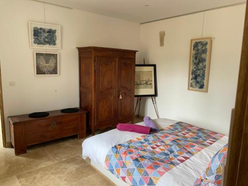 1 dormitorio con 1 cama y armario de madera en lagalerie84, en Saint-Saturnin-lès-Apt