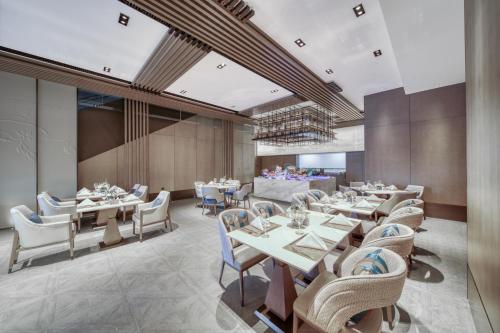 a restaurant with tables and chairs in a room at Wanda Realm Kunming in Kunming