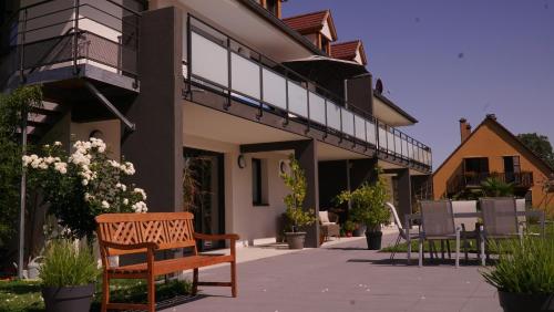 a wooden bench sitting outside of a building at Maison d'Hôtes Sainte Hune Chambres in Hunawihr