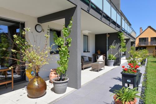 a patio with potted plants on the side of a building at Maison d'Hôtes Sainte Hune Chambres et appartements in Hunawihr