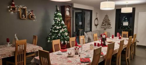 a dining room with a christmas tree in the background at Maison d'Hôtes Sainte Hune Chambres et appartements in Hunawihr