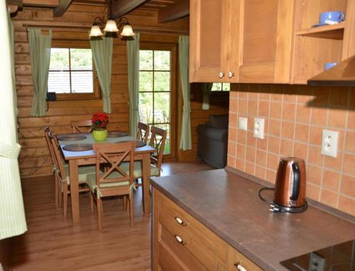 a kitchen and dining room with a table and chairs at Drevenica Desina in Terchová