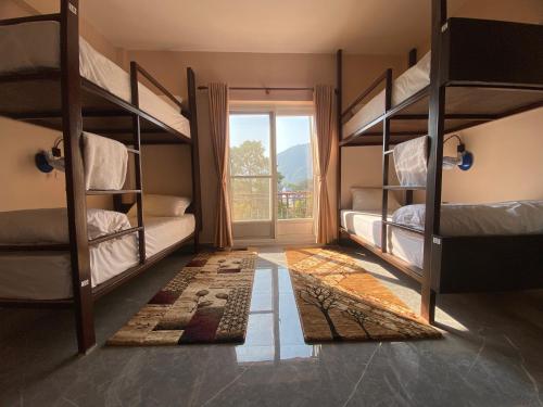 Cette chambre comprend 2 lits superposés et une fenêtre. dans l'établissement Hostel The Good Earth Pvt. Ltd., à Pokhara
