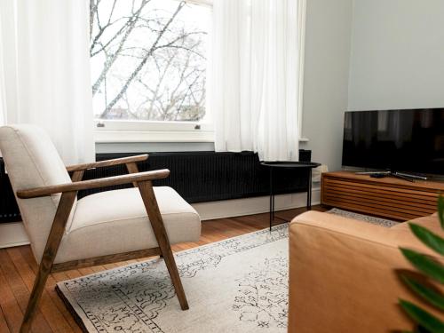 sala de estar con silla y TV en Pass the Keys Modern Condo in Brixton, en Londres