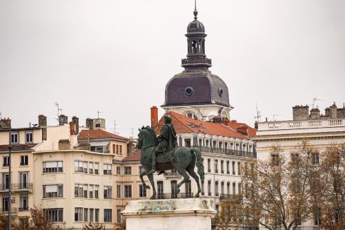 una estatua de un hombre sobre un caballo delante de un edificio en DIFY Chalet a la ville - Parilly, en Vénissieux