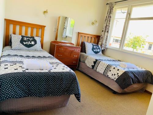a bedroom with two beds and a window at Peaceful House with Kids Playground in Motueka