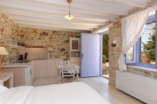 PosidhoníaにあるGood Life Greece Eco Villasのベッドのある寝室とテーブルのあるキッチン