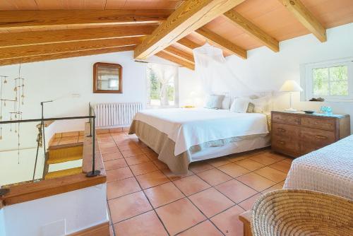 a bedroom with a large bed in a room with wooden ceilings at Ca na Tinta in Algaida