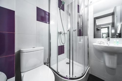a bathroom with a shower and a toilet and a sink at Amarant Hotel by CHM in Kyiv