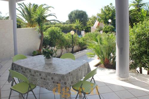 un patio con tavolo, sedie e alberi di Villa Grazia a Ostuni
