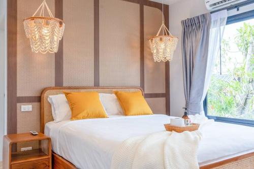 邦濤海灘的住宿－V2 Modern house 3 Beds 3 Baths Bangtao Beach near Boat Avenue，一间卧室配有一张带黄色枕头的床和一扇窗户