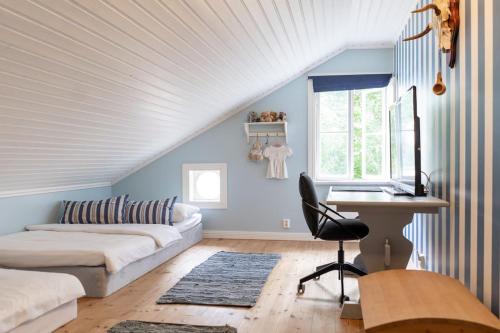 a bedroom with a bed and a desk in a room at Villa Funkis Strömmen - Gorgeous Villa by the sea! in Nauvo