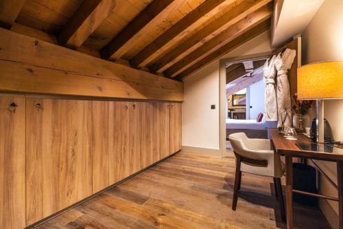 a room with wooden walls and a table and a chair at Les Suites de la Potinière in Courchevel