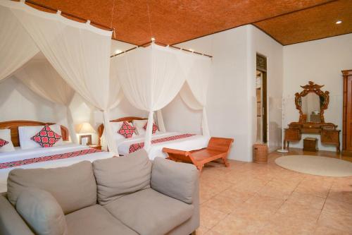 a living room with two beds and a couch at Gayatri in Ubud