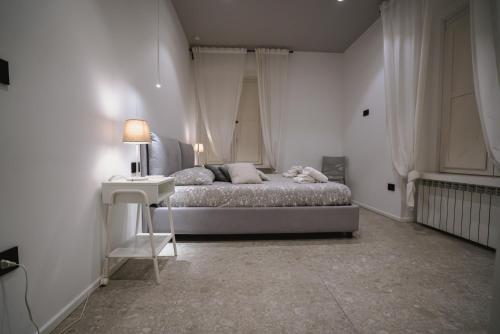 um quarto com uma cama, uma mesa e um candeeiro em De Luca 6 Apartments em Salerno